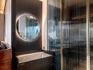 Modern bathroom with round mirror and glass partition