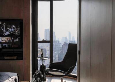 Modern living room with city view, chair, and TV