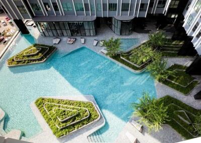 Aerial view of a modern residential building with a unique pool area