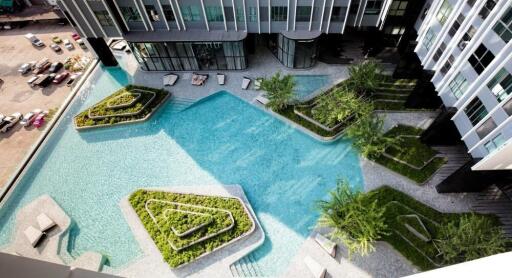 Aerial view of a modern residential building with a unique pool area