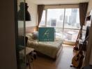 Bedroom with a large window overlooking city, wooden floor and furniture, and musical instruments