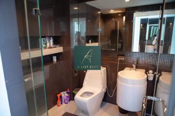 Modern bathroom with glass shower, toilet, and vanity