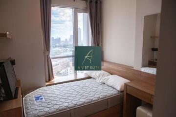 Small bedroom with a single bed, large windows, and a city view