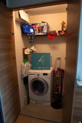 Compact laundry room with washing machine and storage shelves