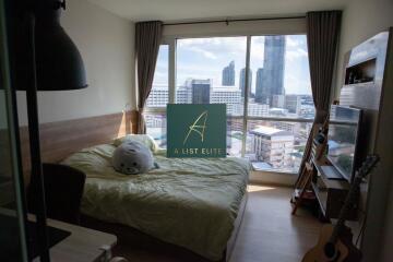 Bedroom with large windows and city view