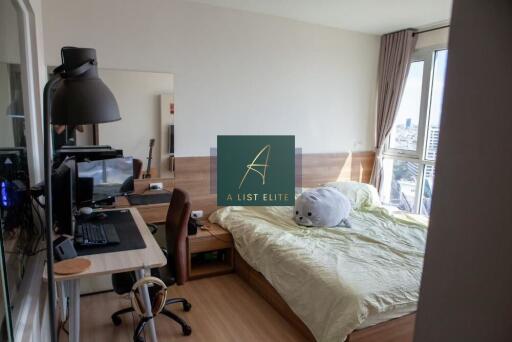 Spacious bedroom with large windows and a work desk