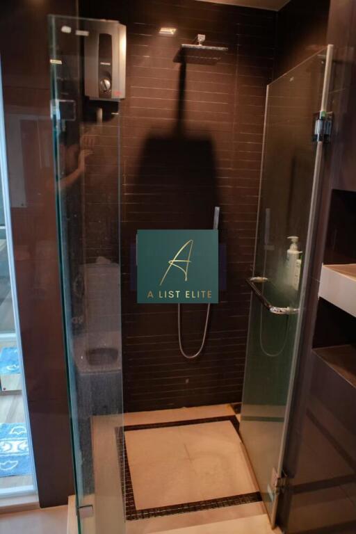 Modern shower with glass doors and dark tiles