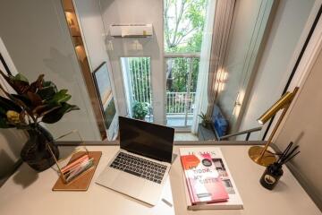 Modern home office with a computer, books, and a window view