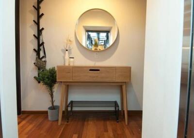 Hallway with wooden console table and round mirror