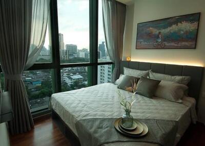 Modern bedroom with large windows and city view