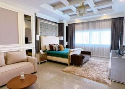 Spacious and elegant bedroom with a couch, TV, and large windows