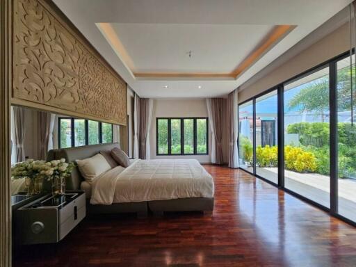 Spacious bedroom with large windows and hardwood floors