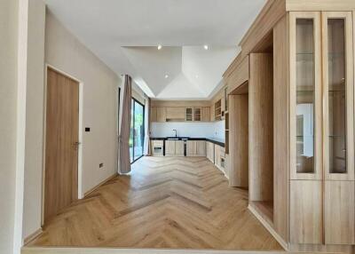 Spacious kitchen with modern wooden cabinets and herringbone-patterned flooring