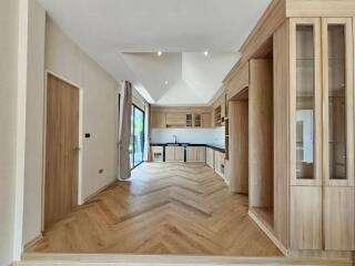 Spacious kitchen with modern wooden cabinets and herringbone-patterned flooring