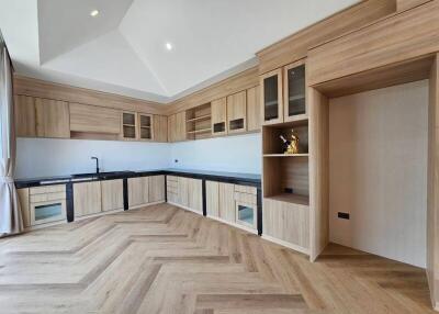 Modern kitchen with wood cabinetry and black countertops