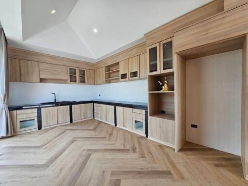 Modern kitchen with wood cabinetry and black countertops