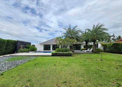 Spacious garden with lush greenery, pool, and seating area