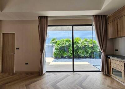 Living room with large glass doors, curtains, and a view of a garden