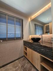 Modern bathroom with wooden vanity and black basin