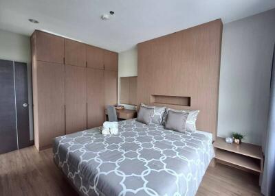 Bedroom with large bed, wooden wardrobes, and bedside tables