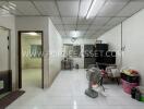 Spacious living area with tiled floor, television, and basic furnishings.