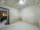 Empty bedroom with tiled floor and ceiling light