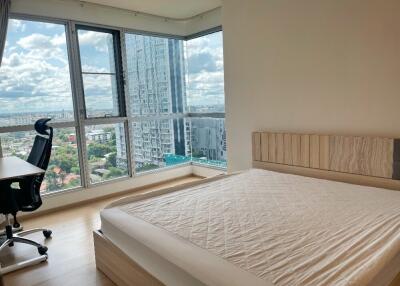 Modern bedroom with large windows and a city view