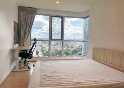 Bright bedroom with large window and city view