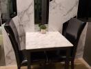 Small dining area with marble table and black chairs