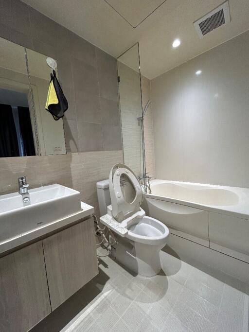 Modern bathroom with bathtub, vanity, and toilet