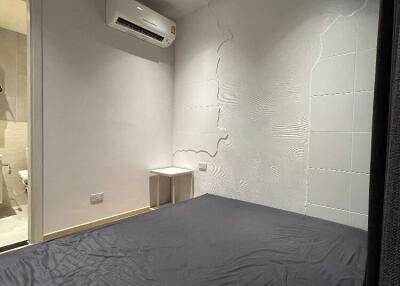 Bedroom with air conditioner and textured wall