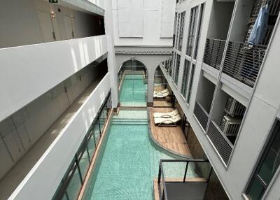 Modern building atrium with indoor pool and overhanging walkways