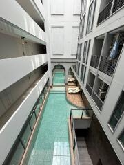 Modern building atrium with indoor pool and overhanging walkways