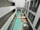 Modern building atrium with indoor pool and overhanging walkways