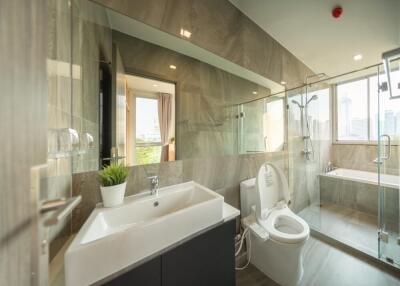 Modern bathroom with glass shower, bathtub, and large mirror