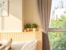 cozy bedroom with sunlight, plants, and a large window