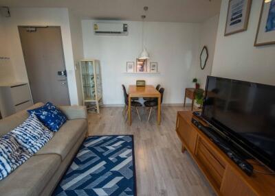 Living room with sofa, TV, dining table, and wall decor