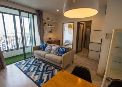 Modern living room with balcony, decorated with contemporary furniture.