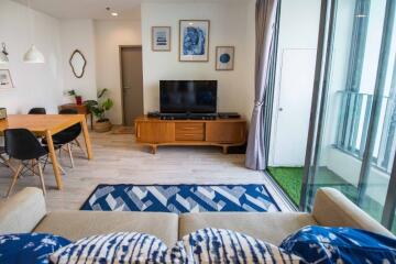 Spacious living room with a dining area, TV, and balcony access