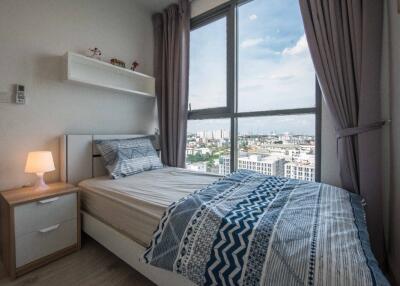 Cozy bedroom with large window and city view