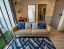 Cozy living room with a beige sofa, blue patterned cushions, and a geometric rug