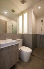 Modern bathroom with vanity, toilet, and shower area