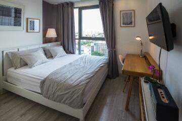 Modern bedroom with a large window and well-lit workspace