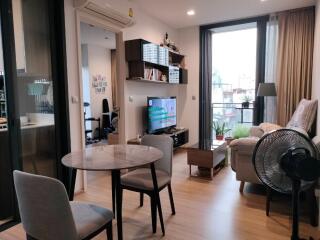 Modern living room with furniture, dining table, and a view of another room