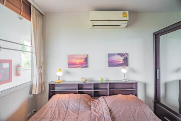 Cozy bedroom with air conditioning and twin artwork