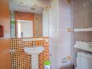 A modern bathroom with tiled walls and a white sink and toilet