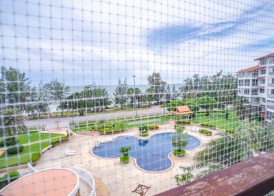 View of swimming pool and ocean from the balcony with safety net