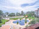 View of swimming pool and ocean from the balcony with safety net