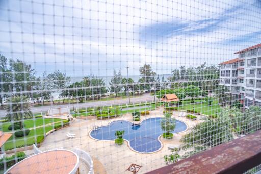 View of swimming pool and ocean from the balcony with safety net