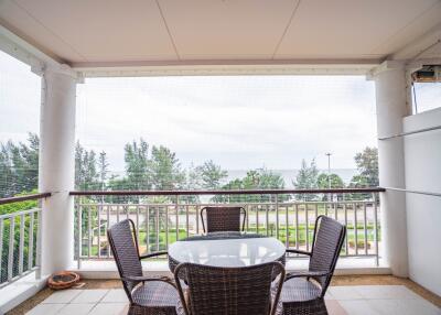 Outdoor balcony with a table and chairs facing a scenic view